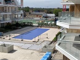 TE HUUR OP JAARBASIS - ongemeubeld appartement in nieuwe residentie - middelgroot zonneterras met zicht op het zwembad - woonkamer met open keuken - 2...