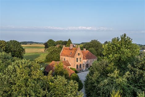 Achter een imposante toegangspoort ontvouwt zich een domein dat niet enkel bewoond wordt, maar beleefd. Een monumentale gevel, tot in de puntjes onder...