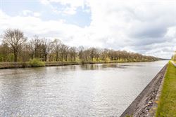 Wonen tussen water en open ruimte. Deze halfopen woning in de Koning Leopoldstraat 71 in Lovendegem kijkt vooraan uit op het Schipdonkkanaal en achter...