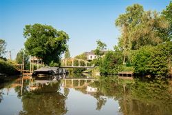 Wonen op een eiland van groen, tussen de Leie en de meersen, en toch vlak bij Gent. Deze karaktervolle woning ligt in een doodlopend straatje in de As...