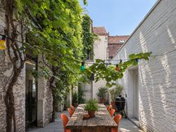 Achter een discrete gevel in de historische binnenstad schuilt iets wat je hier nauwelijks verwacht: een eigenzinnige urban villa met karakter, creati...
