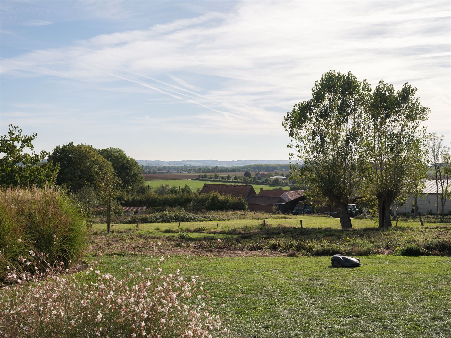 Achter de automatische poort ontvouwt zich een panorama dat je niet snel vergeet. Deze villa in Moregem, vlak bij Oudenaarde, kijkt uit over het glooi...