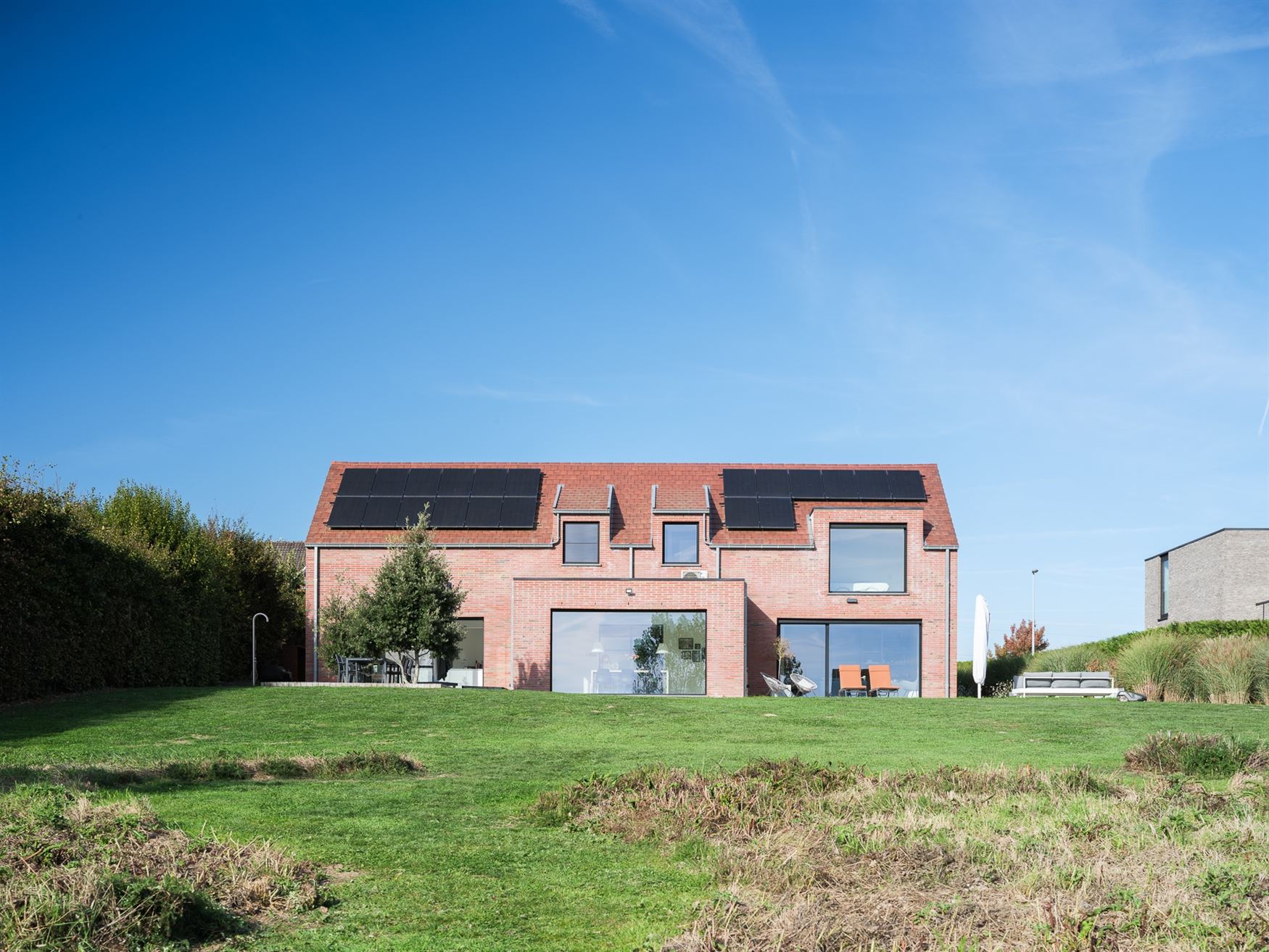 Achter de automatische poort ontvouwt zich een panorama dat je niet snel vergeet. Deze villa in Moregem, vlak bij Oudenaarde, kijkt uit over het glooi...