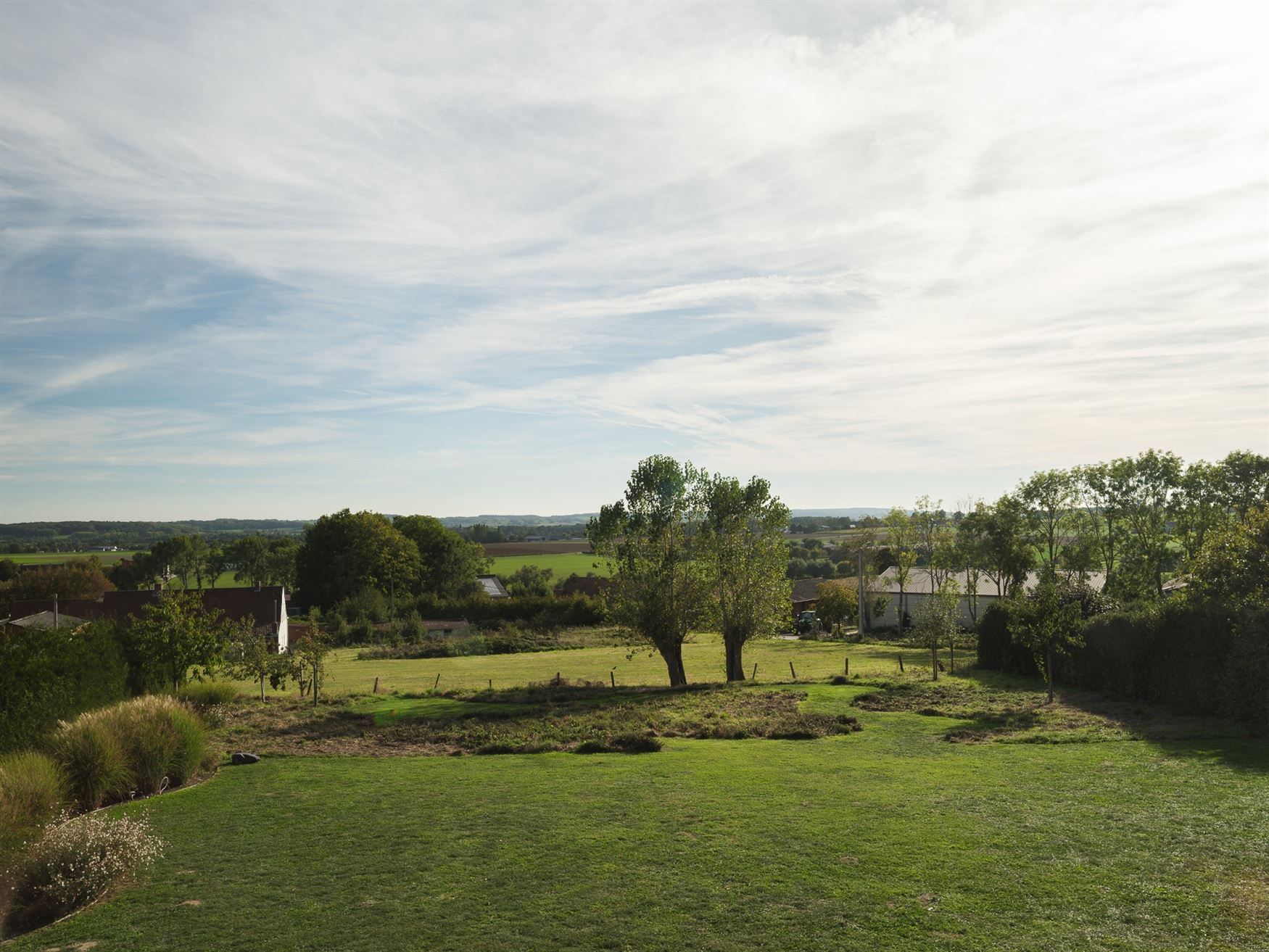Achter de automatische poort ontvouwt zich een panorama dat je niet snel vergeet. Deze villa in Moregem, vlak bij Oudenaarde, kijkt uit over het glooi...