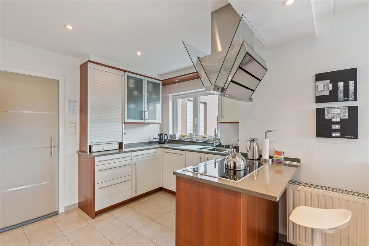 PERFECT ONDERHOUDEN GELIJKVLOERS APPARTEMENT MET 2 SLAAPKAMERS EN RUIME TUIN MET CARPORT EN BERGING TE HEUSDEN