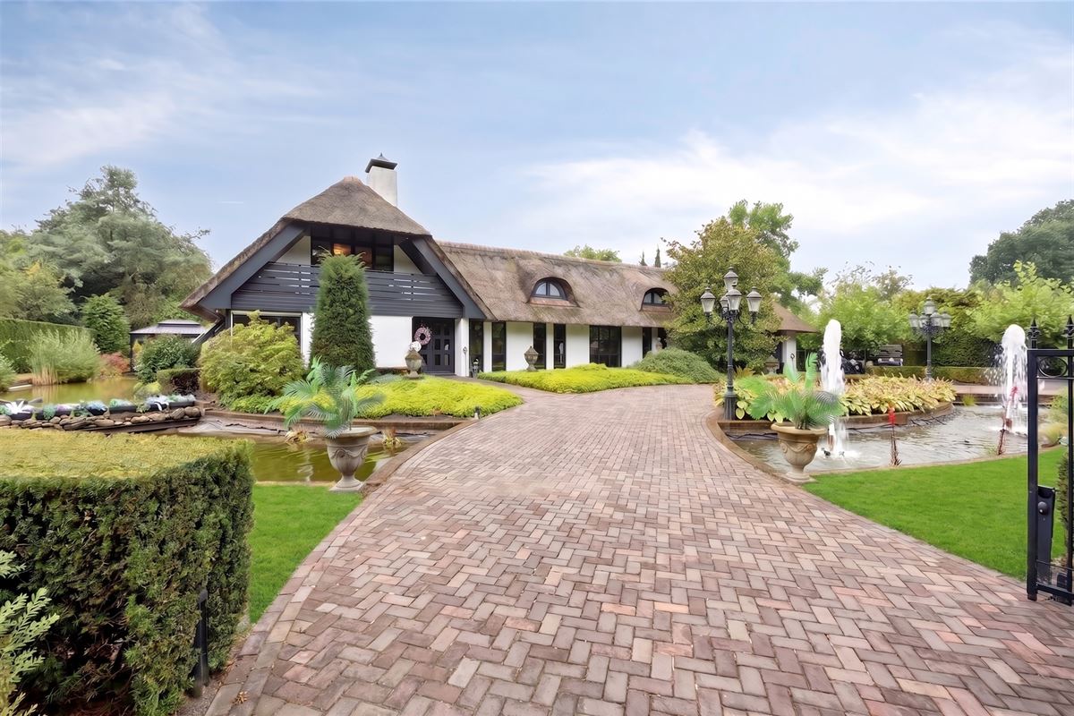 Knappe duo-villa op 8.843 m² in villawijk aan NL-grens.