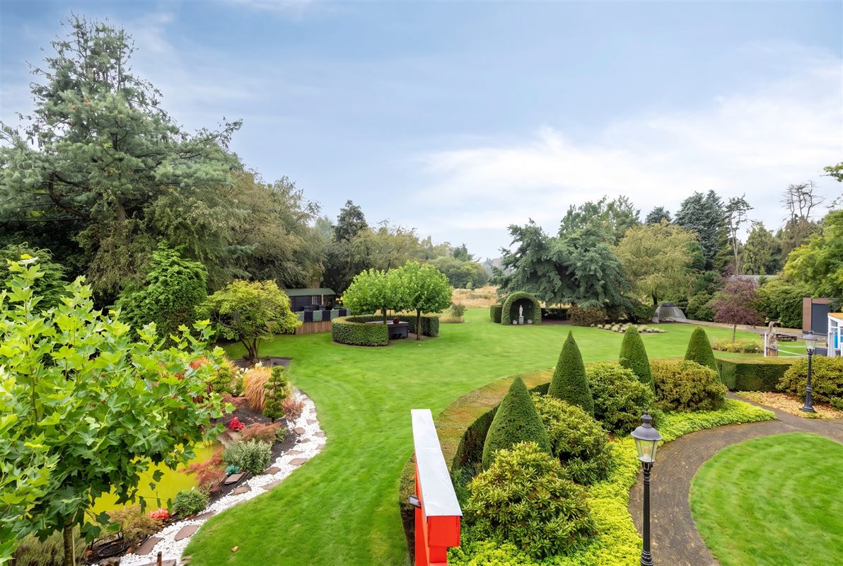 Knappe duo-villa op 8.843 m² in villawijk aan NL-grens.