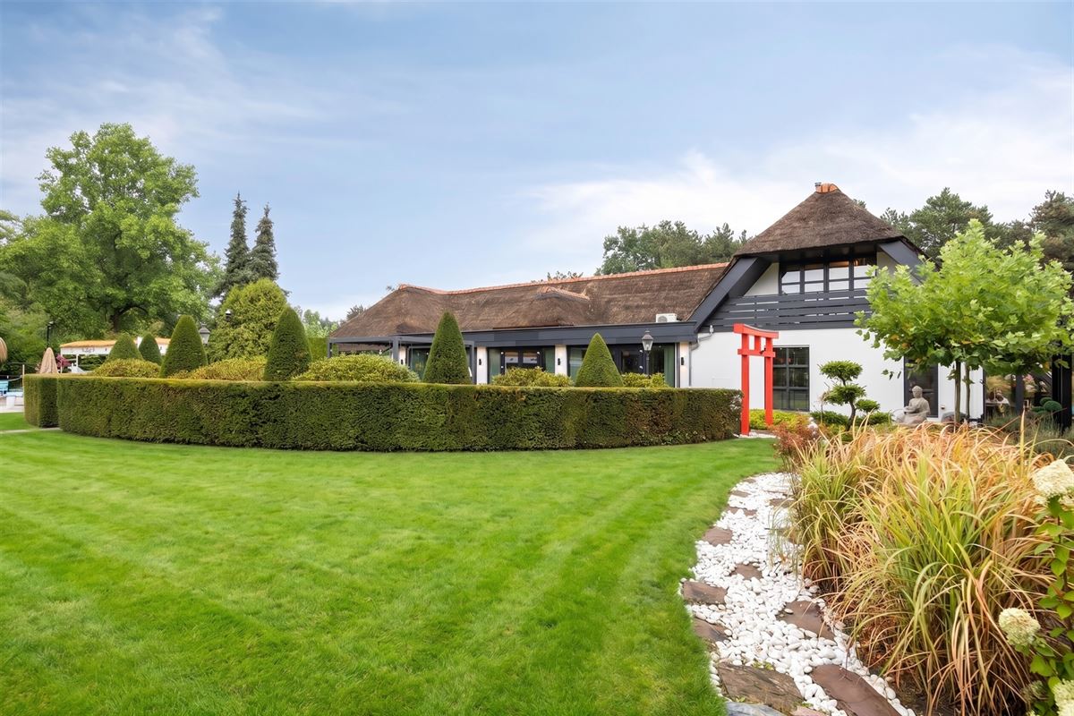 Knappe duo-villa op 8.843 m² in villawijk aan NL-grens.