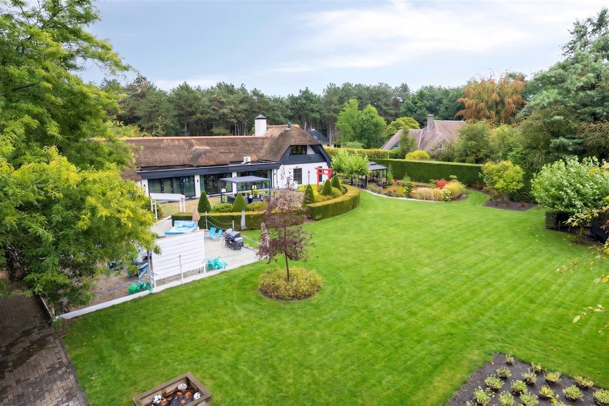 Knappe duo-villa op 8.843 m² in villawijk aan NL-grens.