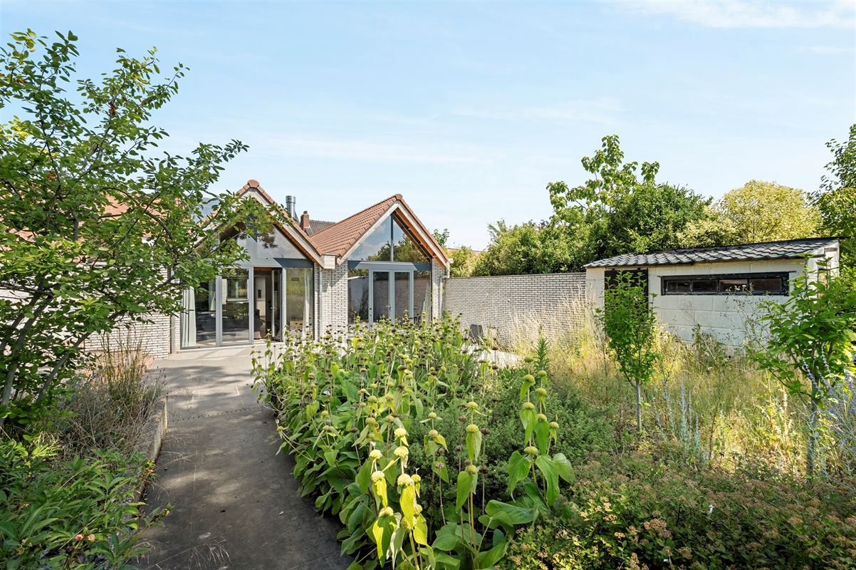 Rijwoning met grote garage/opslag en tuin