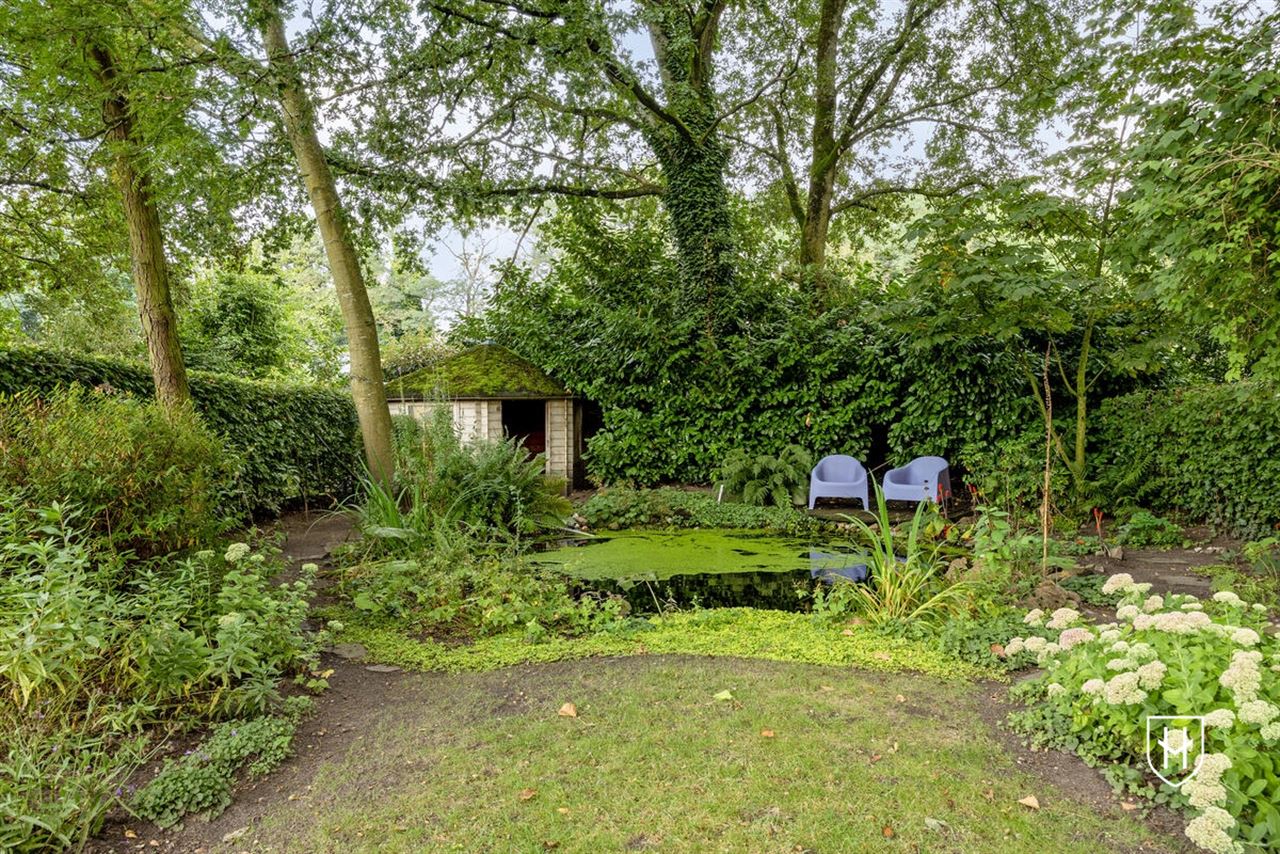 Sfeervolle woning met 2 slaapkamers en prachtig aangelegde tuin met siervijver en terras, centraal gelegen in Peer