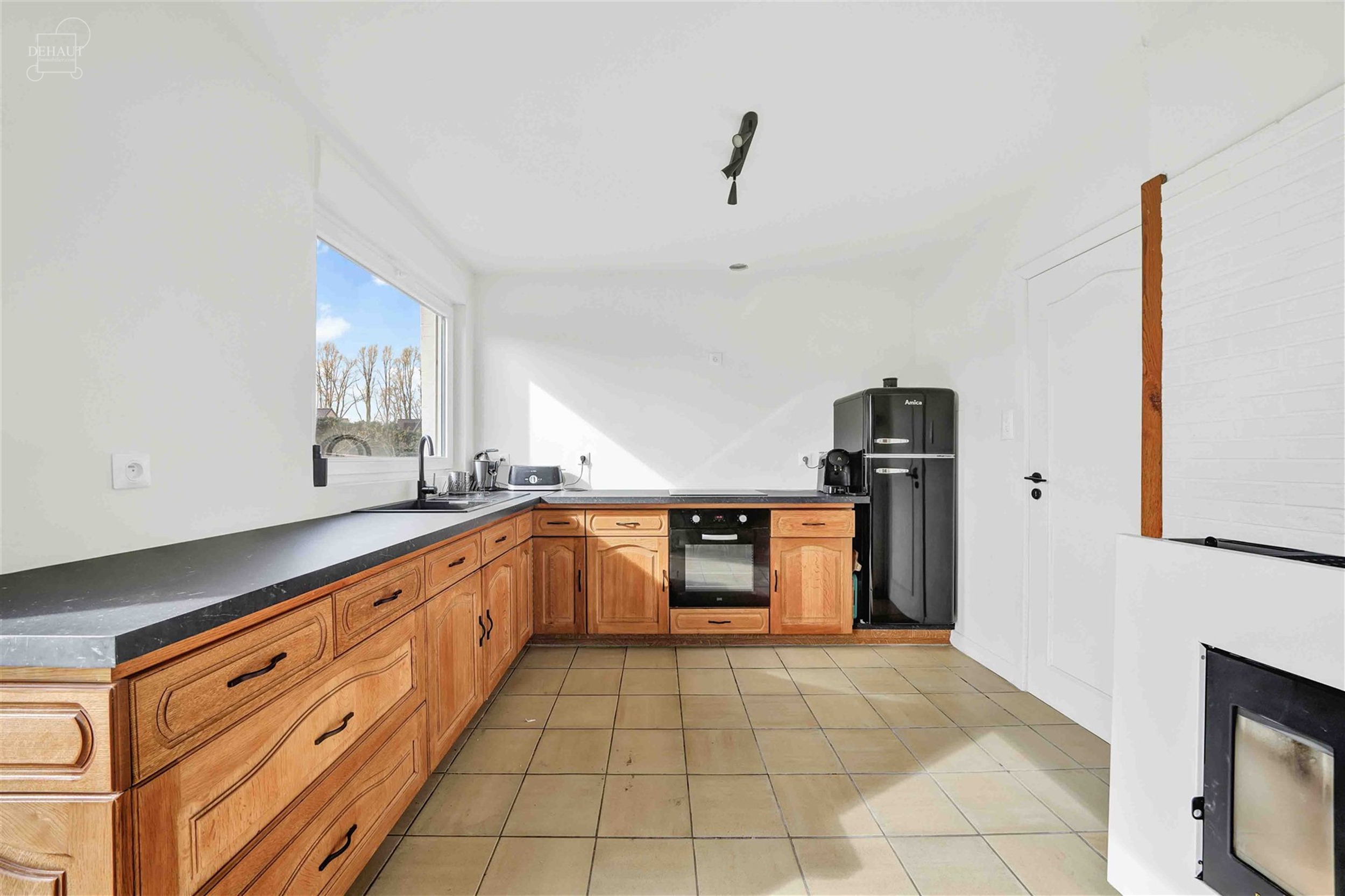 Aantrekkelijk gelijkvloers huis met 3 gevels, volledig uitgegraven met grote garage. Entree, hal die leidt naar een lichte woonkamer met open keuken, ...