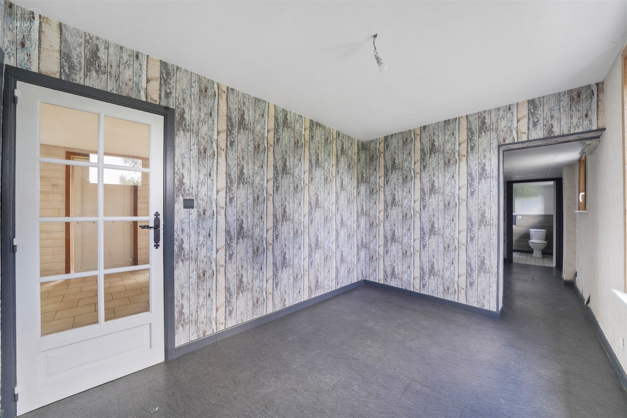 Charmante gelijkvloerse woning, iets terugliggend van een landweggetje, gebouwd op een perceel van ca. 1900 m².
Bestaat uit een woonkamer, een eetkam...