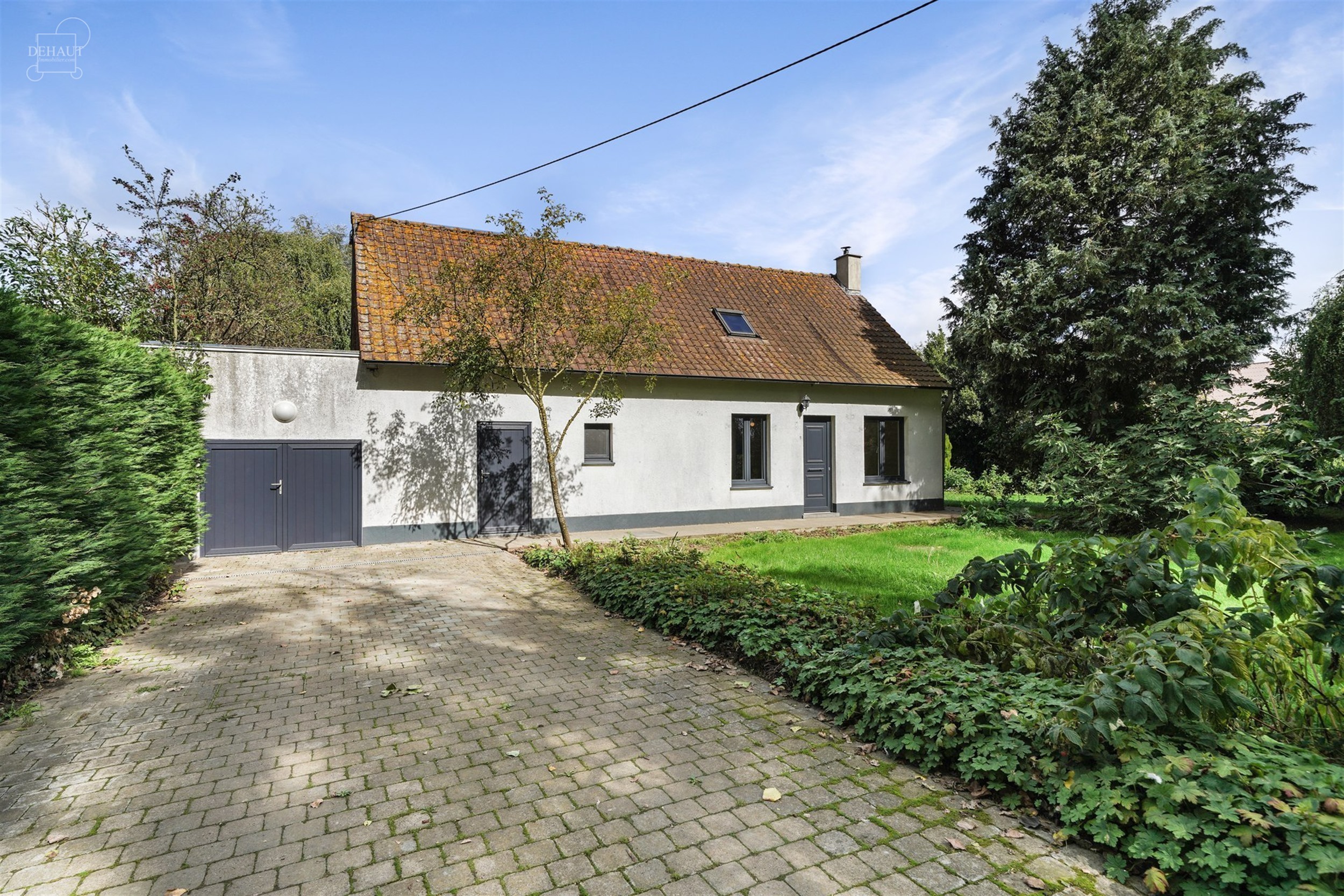 Charmante gelijkvloerse woning, iets terugliggend van een landweggetje, gebouwd op een perceel van ca. 1900 m².
Bestaat uit een woonkamer, een eetkam...