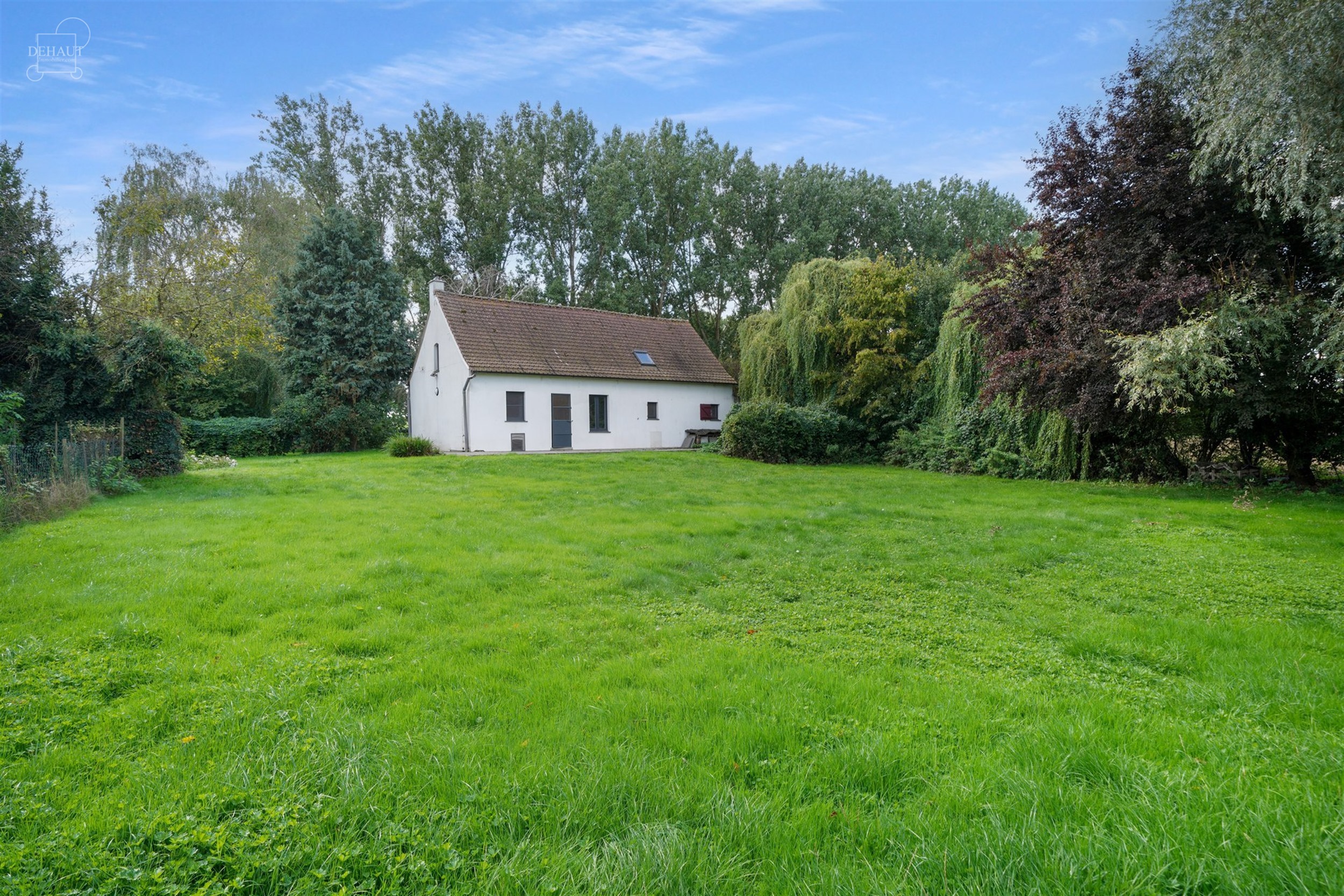 Charmante gelijkvloerse woning, iets terugliggend van een landweggetje, gebouwd op een perceel van ca. 1900 m².
Bestaat uit een woonkamer, een eetkam...