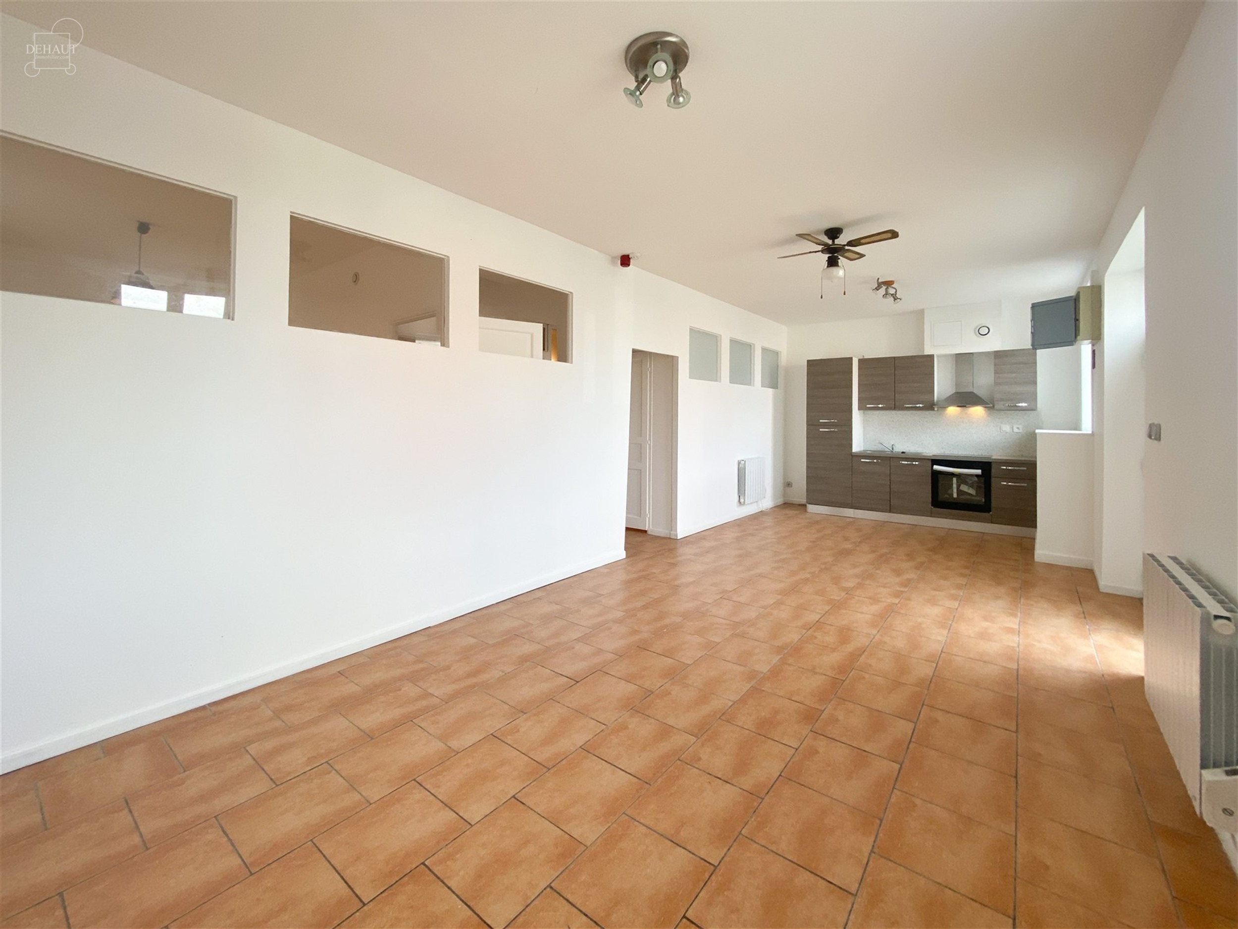 Appartement situé au rez-de-chaussée comprenant un espace de vie ouvert sur une cuisine équipée, une salle de bain avec WC, une chambre et un bure...