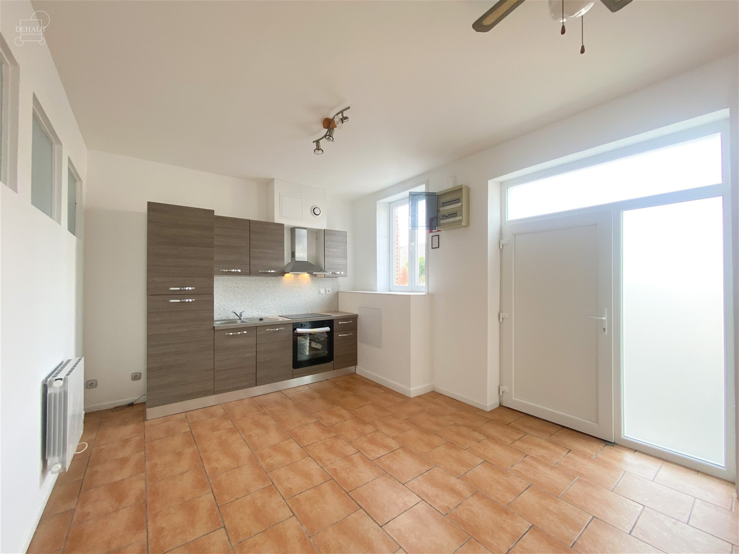Appartement situé au rez-de-chaussée comprenant un espace de vie ouvert sur une cuisine équipée, une salle de bain avec WC, une chambre et un bure...