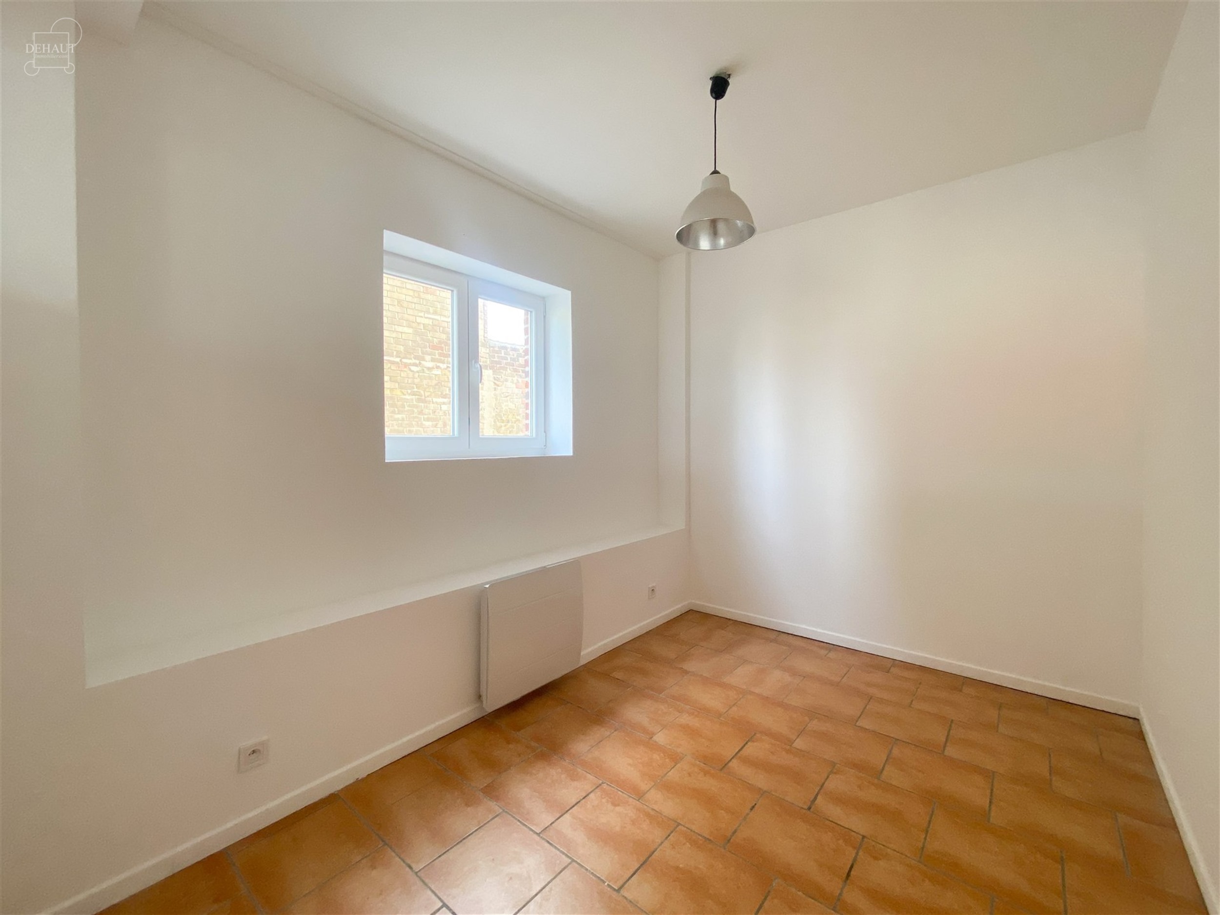 Appartement situé au rez-de-chaussée comprenant un espace de vie ouvert sur une cuisine équipée, une salle de bain avec WC, une chambre et un bure...