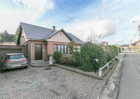 VILLA 4 Ch. - Séjour ± 31 m² avec F.O. - Cuisine hyper-équ.- Véranda ± 25 m² - Sdb et Sdd - Garage - Caves - Jardin SO ± 7 ares 09 ca