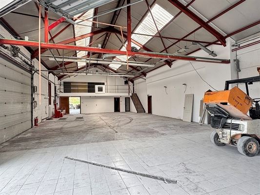 BATIMENT COMMERCIAL / ENTREPOT de ± 275 m² dont une mezzanine de ± 50 m². Façade à rue de ± 19,5 mètres dont ± 4,5 mètres de vitrine en façade. Excellente visibilité sur axe passant et très fréquenté.  Parking privatif de ± 8 places ou parking commun de ± 25 places (à discuter lors de la division). Sanitaires, chaufferie, espace bureau/mezzanine, citerne eaux de pluie. Belles hauteurs sous plafonds
